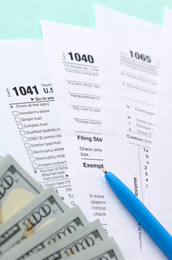 Tax forms lies near hundred dollar bills and blue pen on a light blue background. Income tax return royalty free stock images Tax forms lies near hundred dollar bills and blue pen on a light blue background. Income tax return royalty free stock images