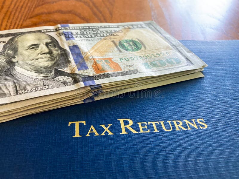 tax-return-cash-sitting-upon-a-blue-leather-tax-portfolio-stock-photo