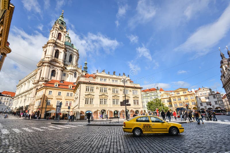 Taxi giallo e chiesa antica di San Nicola in Lesser Town di Praga, repubblica Ceca fotografie stock Taxi giallo e chiesa antica di San Nicola in Lesser Town di Praga, repubblica Ceca fotografie stock
