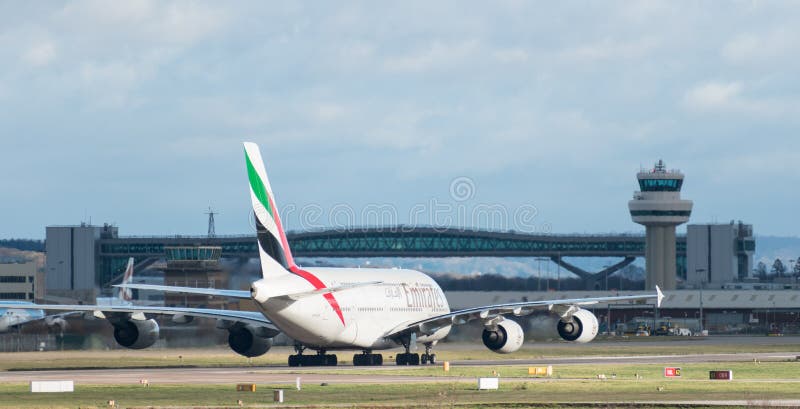 Taxis van een de Luchtvaartlijna380 Luchtbus van Emiraten na het landen bij de Luchthaven van Londen Gatwick met de toren van de royalty-vrije stock foto's Taxis van een de Luchtvaartlijna380 Luchtbus van Emiraten na het landen bij de Luchthaven van Londen Gatwick met de toren van de royalty-vrije stock foto's