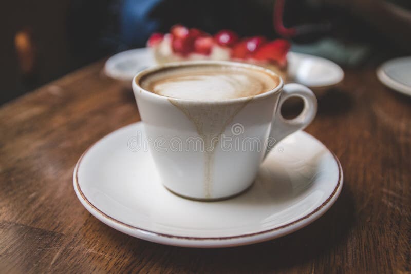 Taza blanca de café del latte con la torta imagen de archivo Taza blanca de café del latte con la torta imagen de archivo