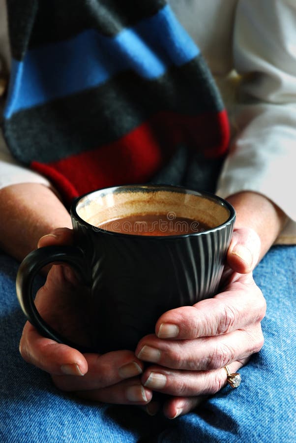 Women's hands holding a warm cup of cocoa. Women's hands holding a warm cup of cocoa