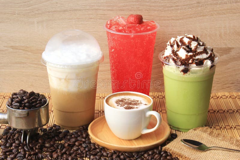 Taza de caf? caliente con los granos de caf? en la tabla de madera, el caf? fr?o, el t? verde helado del matcha y la soda de la f foto de archivo libre de regalías Taza de caf? caliente con los granos de caf? en la tabla de madera, el caf? fr?o, el t? verde helado del matcha y la soda de la f foto de archivo libre de regalías