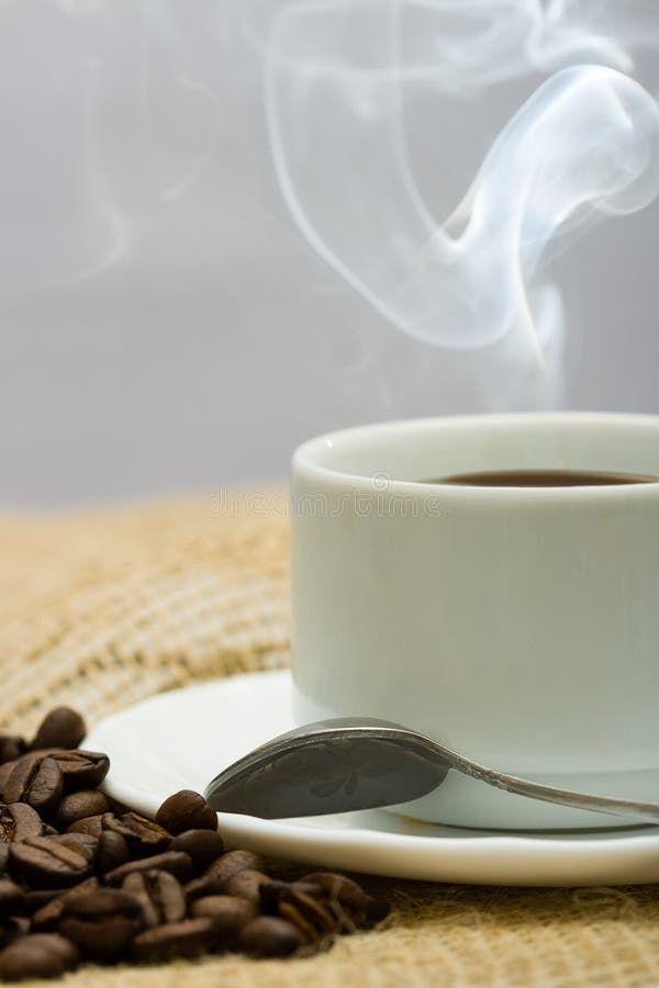 Closeup macro cup of hot coffee with coffee beans. Closeup macro cup of hot coffee with coffee beans