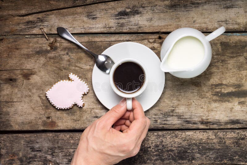 Taza de café con el jarro de leche en los antecedentes de madera. fotografía de archivo