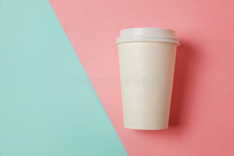 Taza de café de papel en fondo azul y rosado fotografía de archivo libre de regalías Taza de café de papel en fondo azul y rosado fotografía de archivo libre de regalías