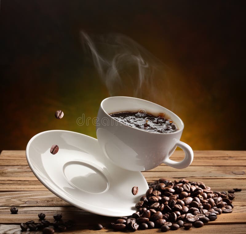 Falling coffee cup on the table. There are coffee beans on a old wooden table. Falling coffee cup on the table. There are coffee beans on a old wooden table.