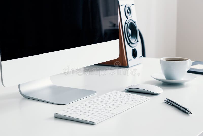 Taza de café, de teclado y de equipo de escritorio en el escritorio en el interior blanco de Ministerio del Interior Foto verdade