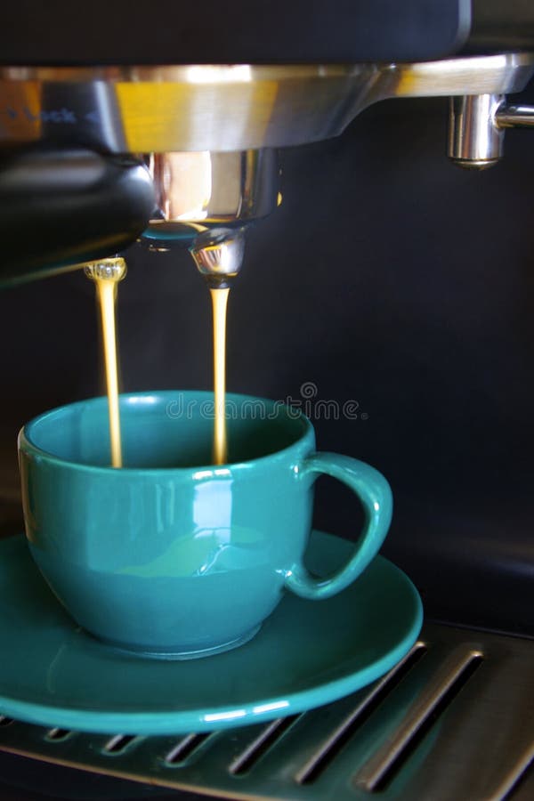 Close up of espresso coffee machine dispensing coffee into a green coffee cup. Close up of espresso coffee machine dispensing coffee into a green coffee cup.