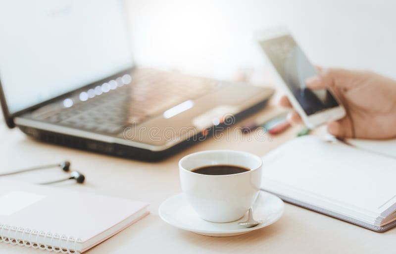 Taza de café y de teléfono elegante con la mano del hombre de negocios que usa el ordenador portátil foto de archivo Taza de café y de teléfono elegante con la mano del hombre de negocios que usa el ordenador portátil foto de archivo