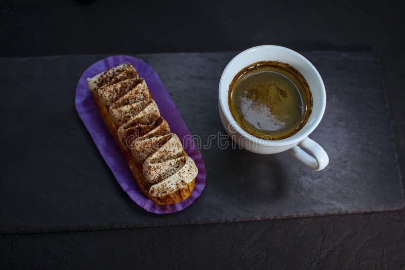 Taza de café y deliciosa tarta de eclair con sabor a tiramisú foto de archivo