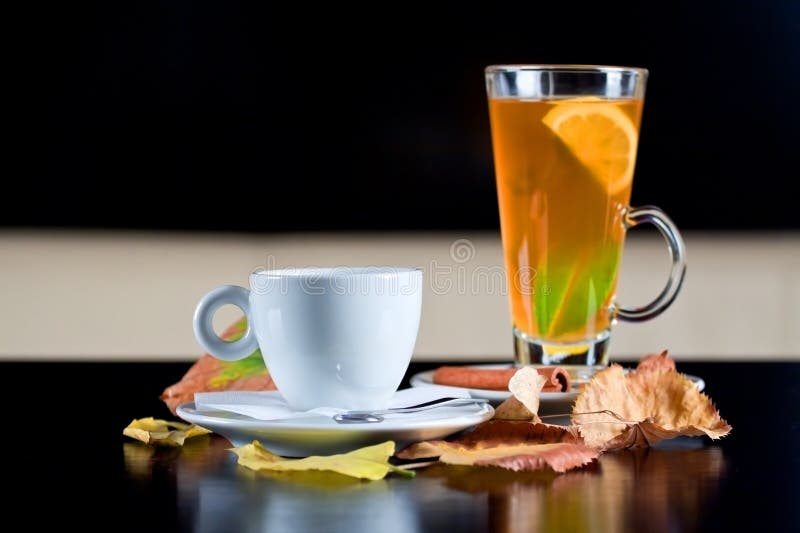 Taza de café y vidrio del té al lado de las hojas de otoño fotos de archivo Taza de café y vidrio del té al lado de las hojas de otoño fotos de archivo