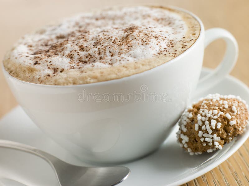 Close up of Cup of Cappucino with an Amaretti Biscuit. Close up of Cup of Cappucino with an Amaretti Biscuit