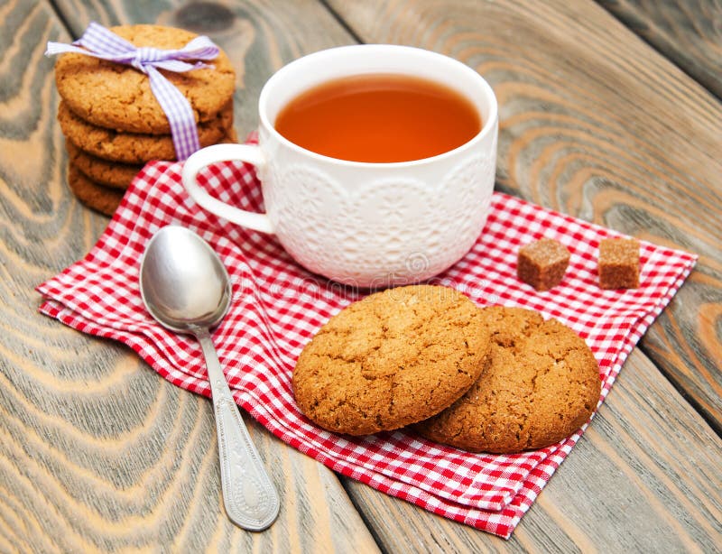 Taza de té con las galletas de harina de avena imagen de archivo Taza de té con las galletas de harina de avena imagen de archivo
