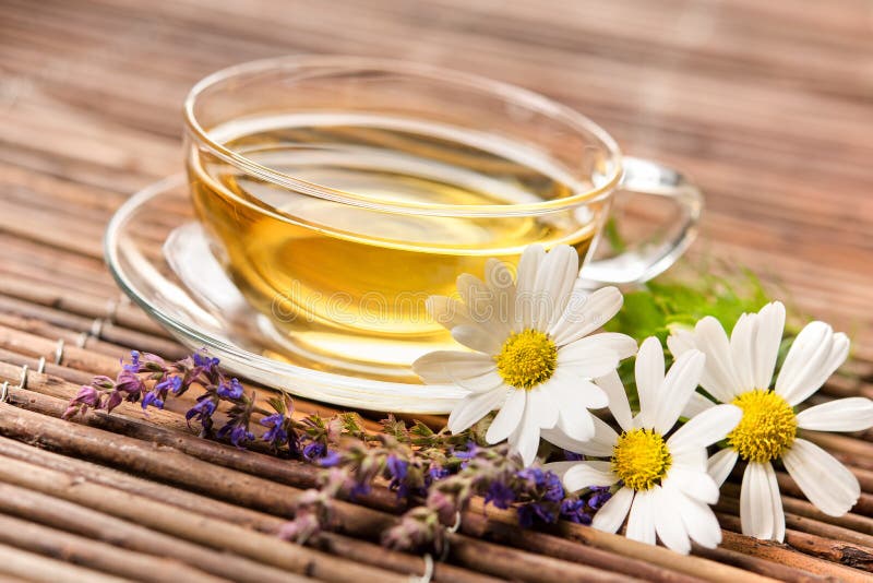 Cup of herbal tea with chamomile flowers on wooden background. Cup of herbal tea with chamomile flowers on wooden background