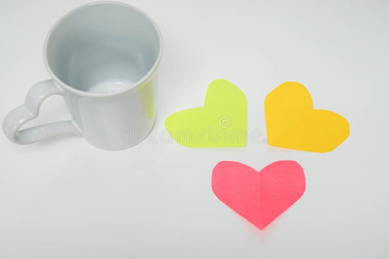 Tazza bianca con le carte variopinte del cuore immagini stock Tazza bianca con le carte variopinte del cuore immagini stock