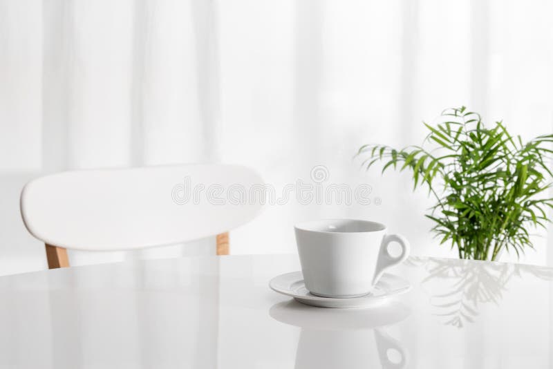 Tazza bianca sul tavolo da cucina fotografie stock libere da diritti Tazza bianca sul tavolo da cucina fotografie stock libere da diritti