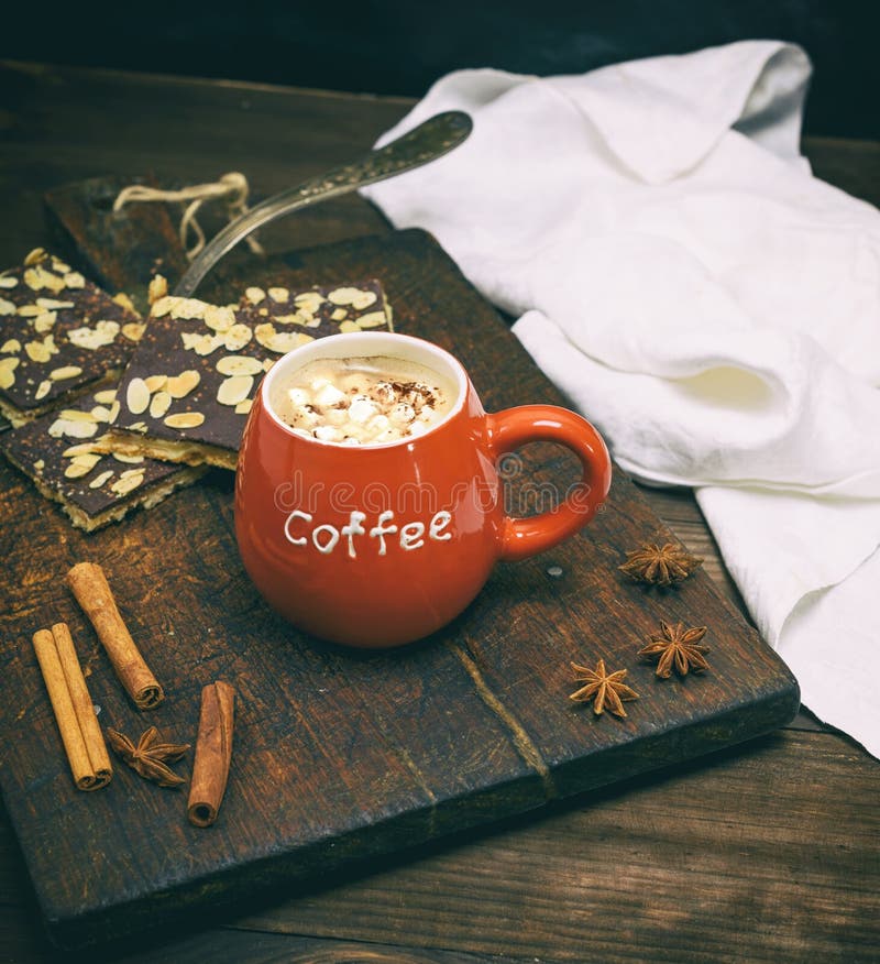 Tazza ceramica rossa con caffè su un fondo di legno marrone immagine stock libera da diritti Tazza ceramica rossa con caffè su un fondo di legno marrone immagine stock libera da diritti