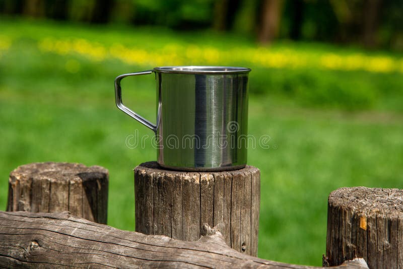 Tazza d'acciaio turistica nella foresta di estate all'aperto fotografia stock Tazza d'acciaio turistica nella foresta di estate all'aperto fotografia stock
