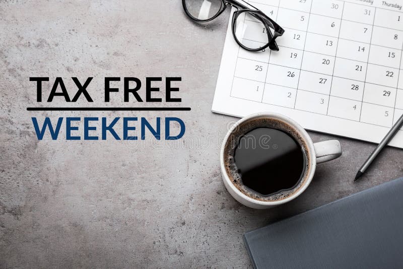 Cup of coffee, stationery and text TAX FREE WEEKEND on grey table, flat lay. Cup of coffee, stationery and text TAX FREE WEEKEND on grey table, flat lay