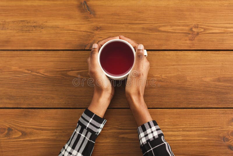 Tazza di caffè della tenuta della donna di colore, vista superiore fotografia stock