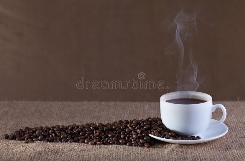 Cup of fresh and hot steaming coffee on burlap surface. Cup of fresh and hot steaming coffee on burlap surface