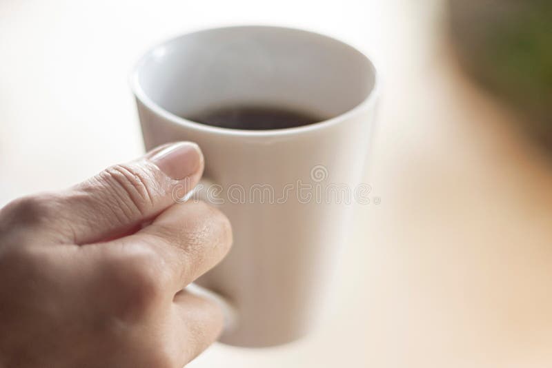 Tazza di caffè femminile della tenuta della mano immagini stock Tazza di caffè femminile della tenuta della mano immagini stock