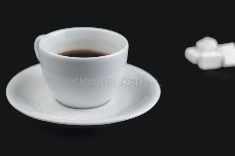 Tazza di caffè macchiato con i cubi dello zucchero isolati su un fondo nero fotografie stock libere da diritti Tazza di caffè macchiato con i cubi dello zucchero isolati su un fondo nero fotografie stock libere da diritti