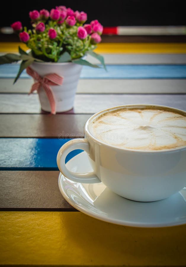 Tazza di caffè macchiato sulla tavola di legno variopinta fotografia stock Tazza di caffè macchiato sulla tavola di legno variopinta fotografia stock
