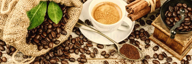 Tazza di caffè nero caldo con la vecchie smerigliatrice e tela da imballaggio di legno del mulino immagine stock libera da diritti