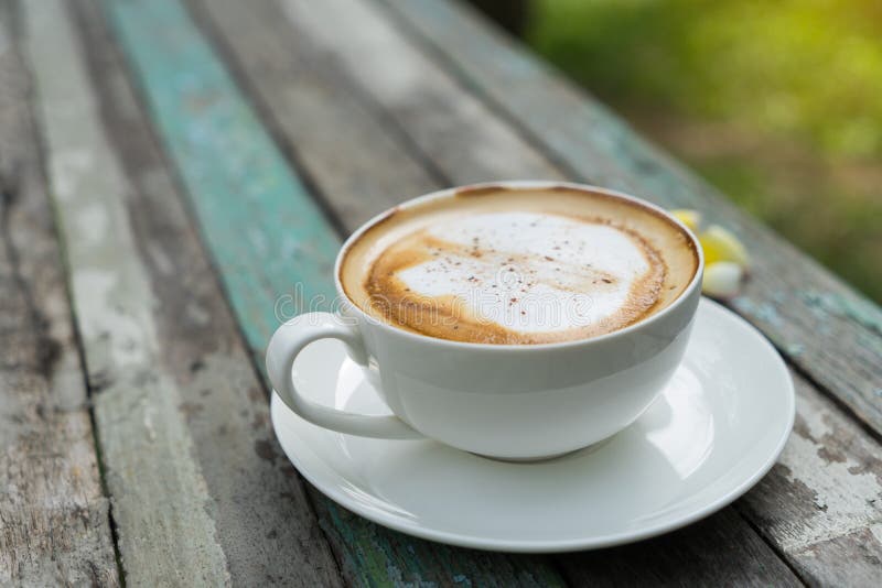 Tazza di Coffe sulla vecchia tavola di legno in parco fotografia stock libera da diritti Tazza di Coffe sulla vecchia tavola di legno in parco fotografia stock libera da diritti