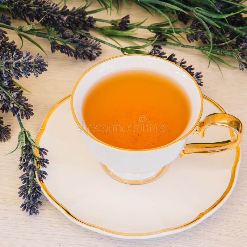 Tazza di tè con il fiore su una vista superiore del fondo di legno fotografie stock Tazza di tè con il fiore su una vista superiore del fondo di legno fotografie stock