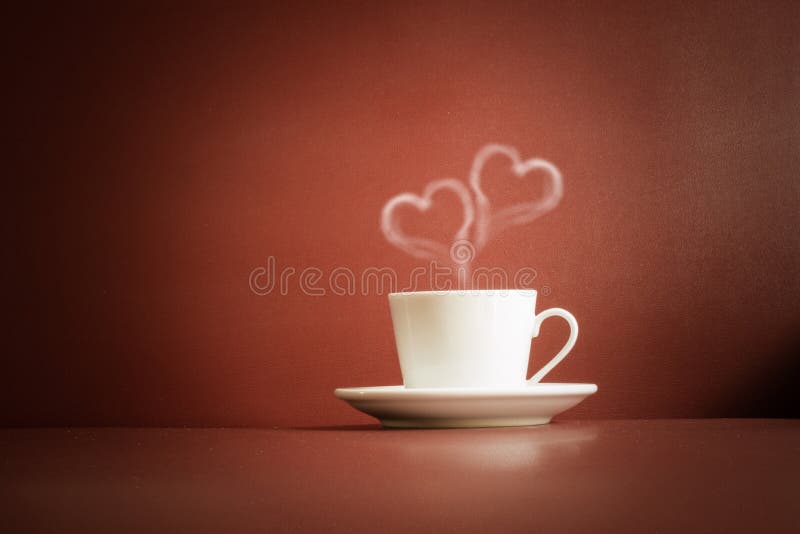 Tazza di tè con vapore in una forma di due cuori fotografie stock libere da diritti Tazza di tè con vapore in una forma di due cuori fotografie stock libere da diritti