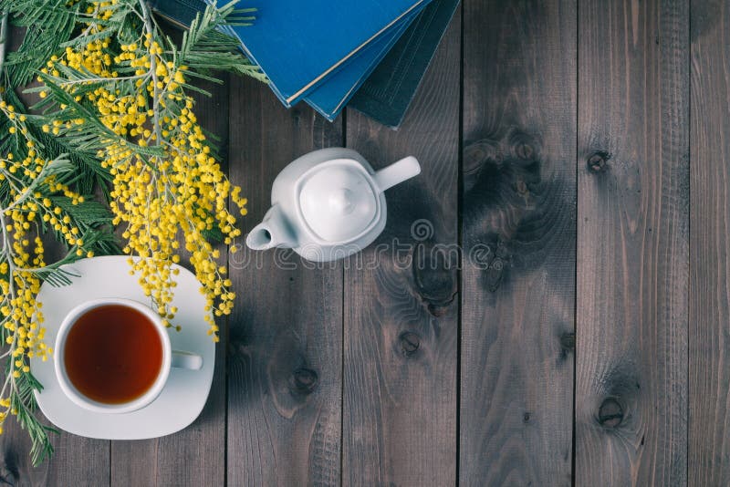 Tazza di tè e libri sulla tavola di legno fotografia stock libera da diritti Tazza di tè e libri sulla tavola di legno fotografia stock libera da diritti