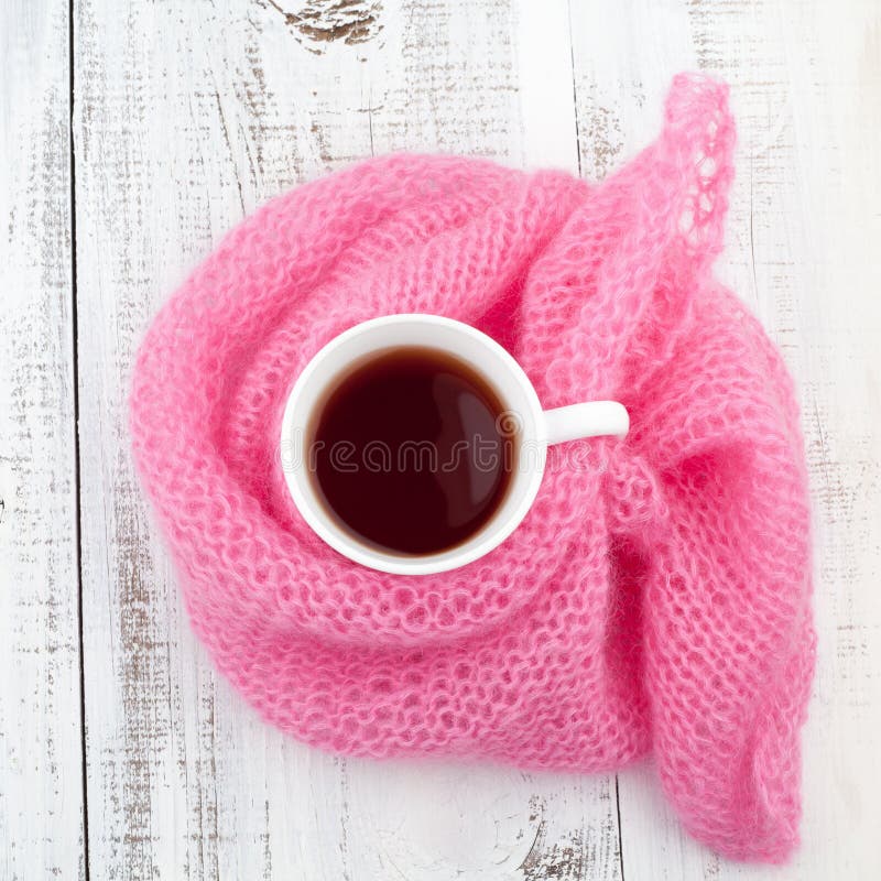 Tazza di tè nella sciarpa di tricottare immagine stock libera da diritti Tazza di tè nella sciarpa di tricottare immagine stock libera da diritti