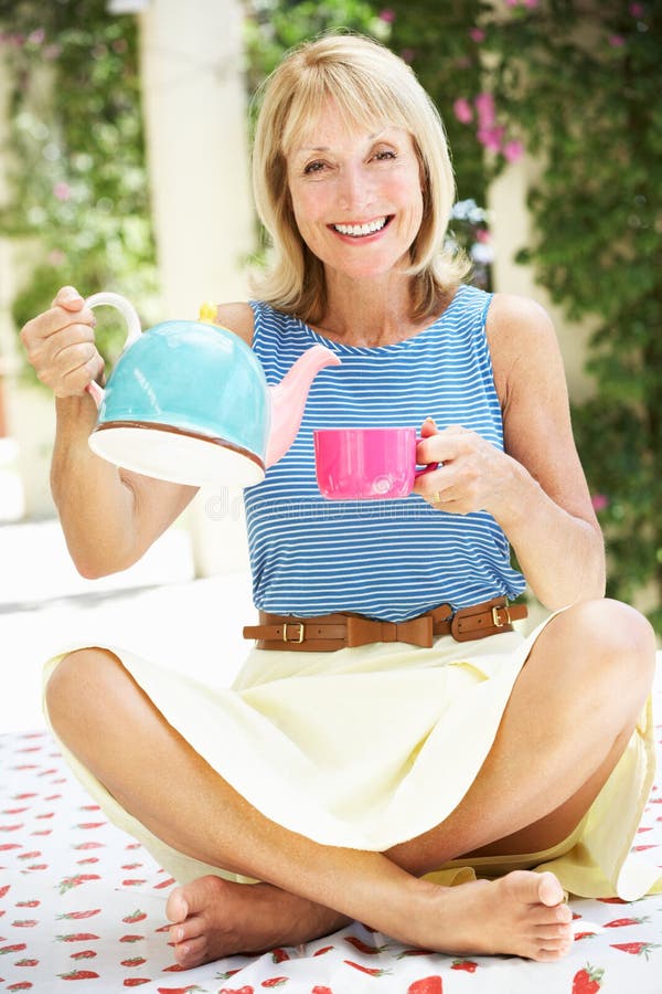 Tazza di versamento della donna maggiore di tè immagine stock Tazza di versamento della donna maggiore di tè immagine stock