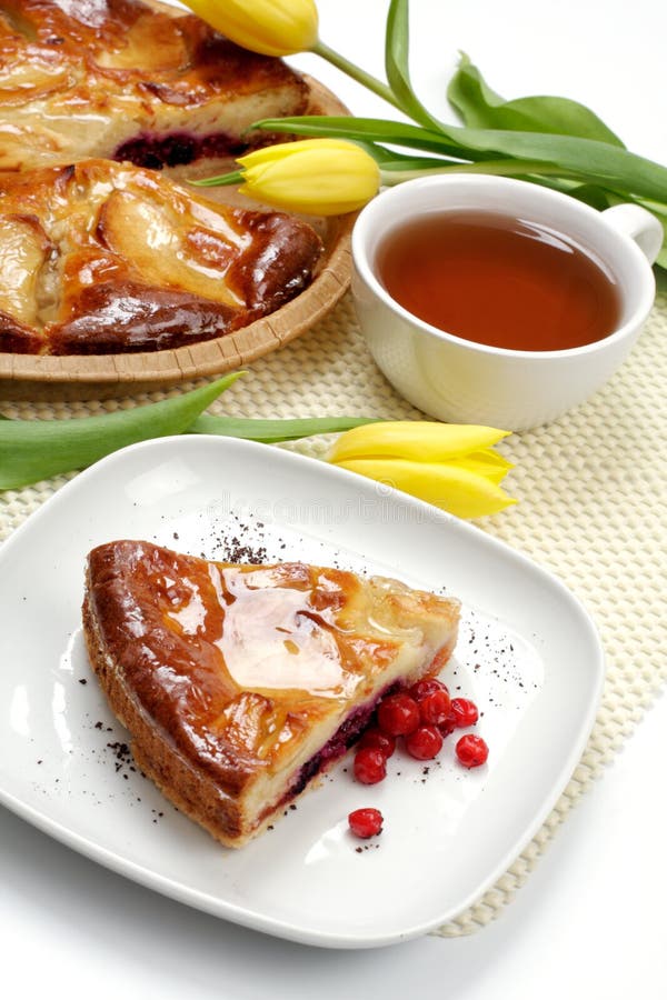 Tazza, tulipani e parte di tè di un grafico a torta di mela fotografia stock libera da diritti Tazza, tulipani e parte di tè di un grafico a torta di mela fotografia stock libera da diritti