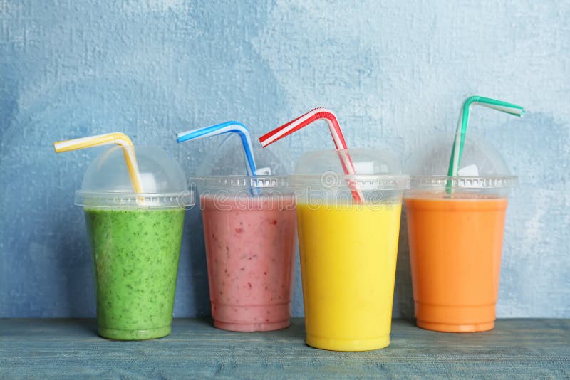 Tazze di plastica con i frullati deliziosi della disintossicazione immagini stock libere da diritti Tazze di plastica con i frullati deliziosi della disintossicazione immagini stock libere da diritti