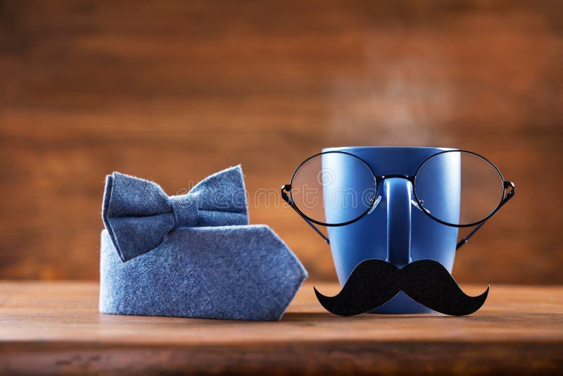 Cup of coffee, eyeglasses, mustache and bowtie for creative breakfast on Fathers Day. Greeting card for daddy. Cup of coffee, eyeglasses, mustache and bowtie for creative breakfast on Fathers Day. Greeting card for daddy