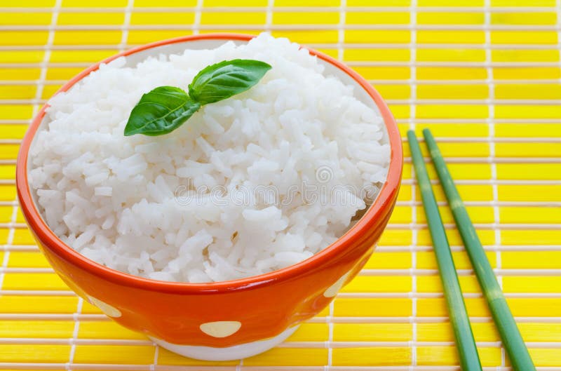 Bowl of steamed rice on yellow with bamboo chopsticks. Bowl of steamed rice on yellow with bamboo chopsticks