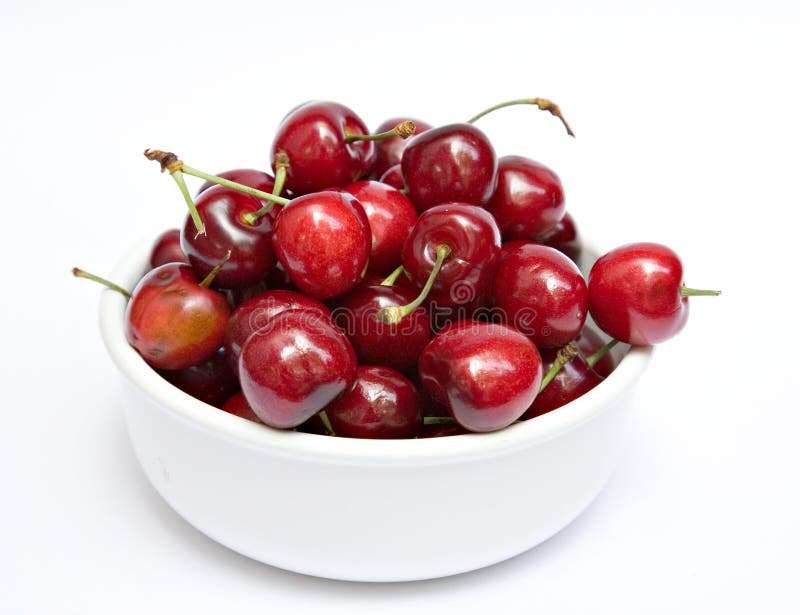 A white bowl of cherries on a white background. A white bowl of cherries on a white background.