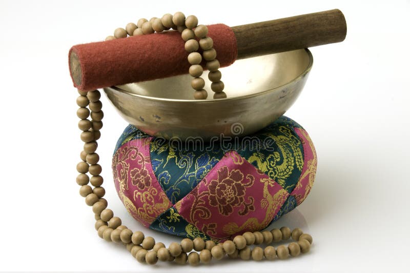 Tibetan singing bowl on quilted stand with sandalwood prayer beads. Tibetan singing bowl on quilted stand with sandalwood prayer beads