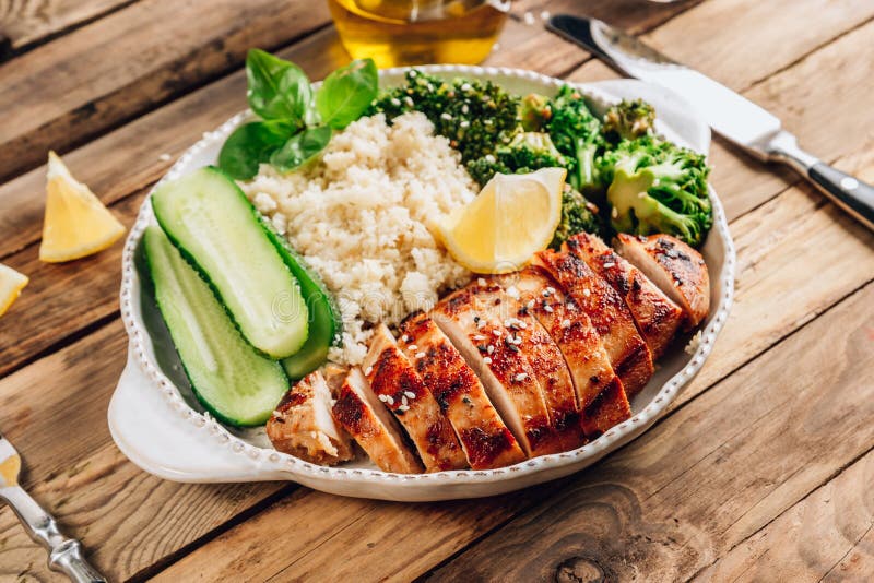 Taça de almoço keto. frango grelhado com brócolis e pepino de arroz couve-flor fotos de stock royalty free