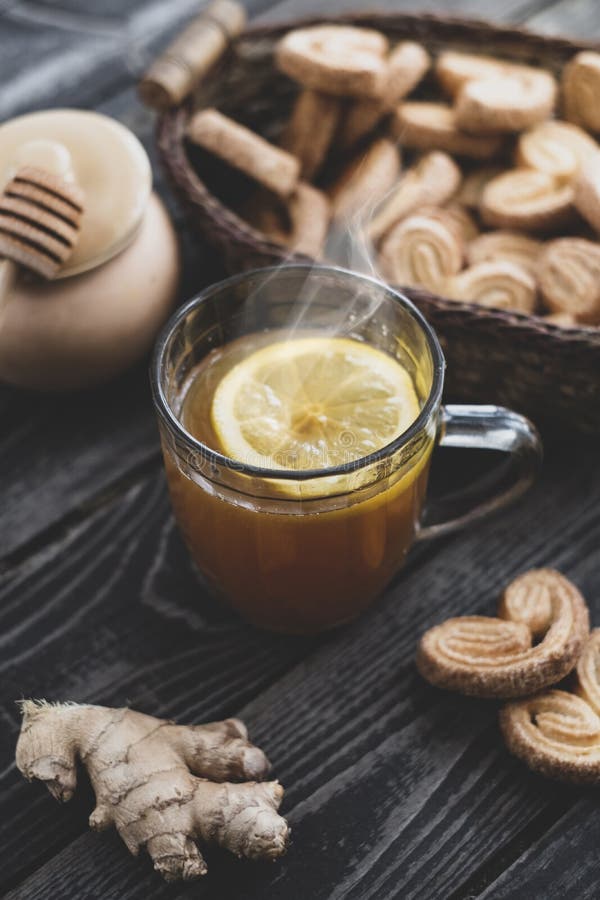 Te med citronhonung och ingefära med kakor med gigingerbröd på träbakgrund royaltyfri bild
