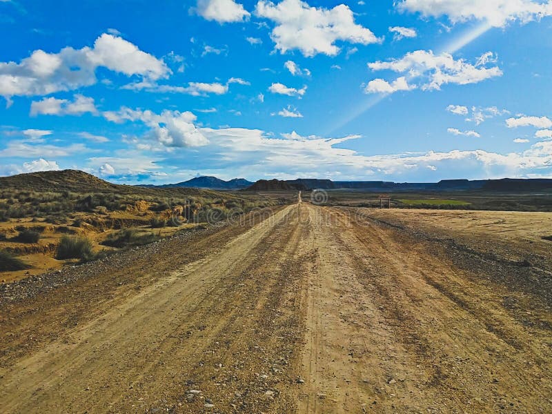 Te verlaten weg en hemel in Bardenas Reales, Navarra, Spanje royalty-vrije stock fotografie Te verlaten weg en hemel in Bardenas Reales, Navarra, Spanje royalty-vrije stock fotografie