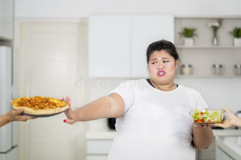 Te zware vrouw die pizza weigeren te eten stock fotografie Te zware vrouw die pizza weigeren te eten stock fotografie