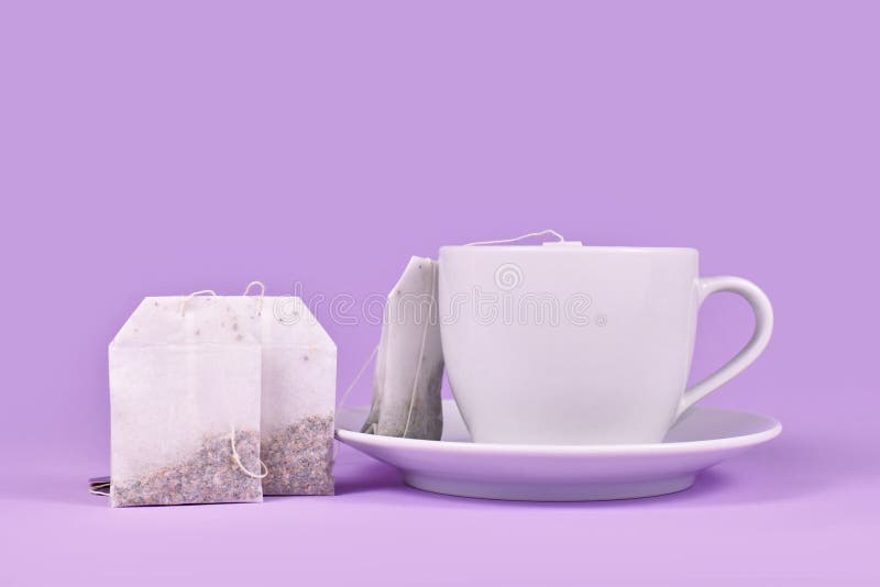 Tea Cup with Herbal Tea Bags on Violet Background Stock Photo Image