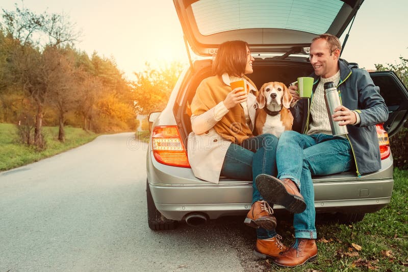 Tea party in car truck - loving couple with dog sits in car truck