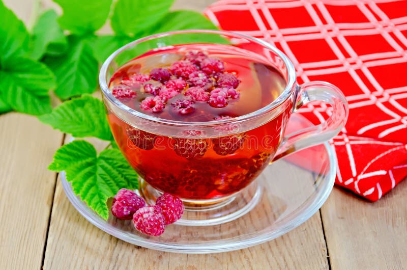 Tea with raspberry and a napkin on board