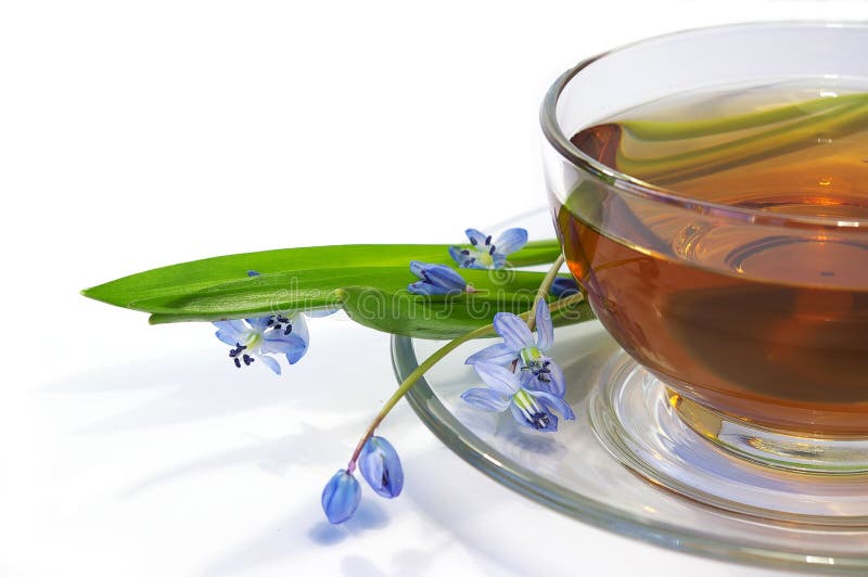 Tea in a transparent cup and flowers